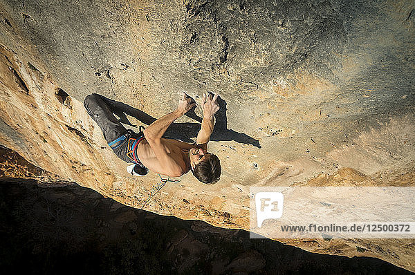 A man climbing 'La tentaci??n de seguir ' a hard route full of monofinger in Sierra de Guara