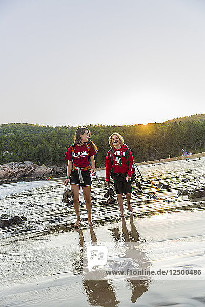 Boy And Girl Walking On Sand Beach Barefoot In Acadia National Park