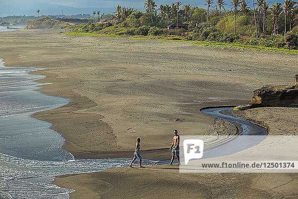 Ein Paar spaziert am Strand von Bali. Indonesien