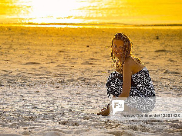 Junge Frau am Strand bei Sonnenuntergang.