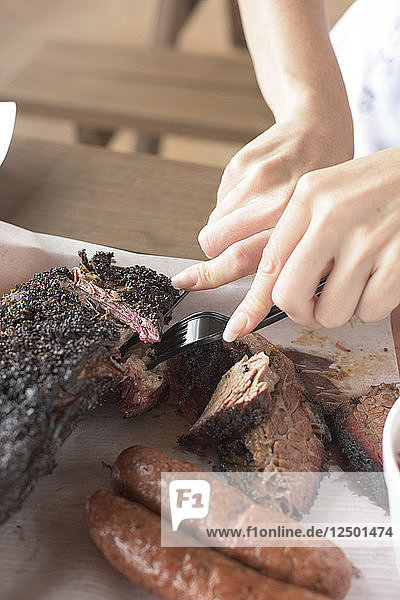 Die Hände einer Frau schneiden in einem Barbecue-Restaurant in der Nähe von Houston  Texas  in die Rinderbrust.