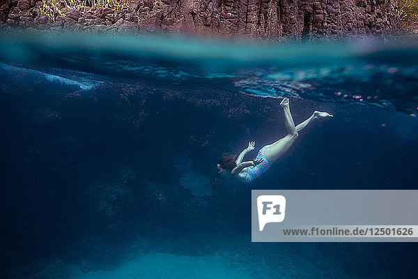 Young woman diving underwater.