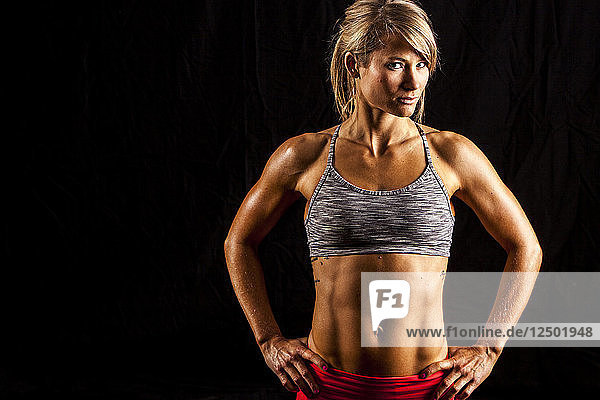 Muscular woman with hands on hips and six pack abs