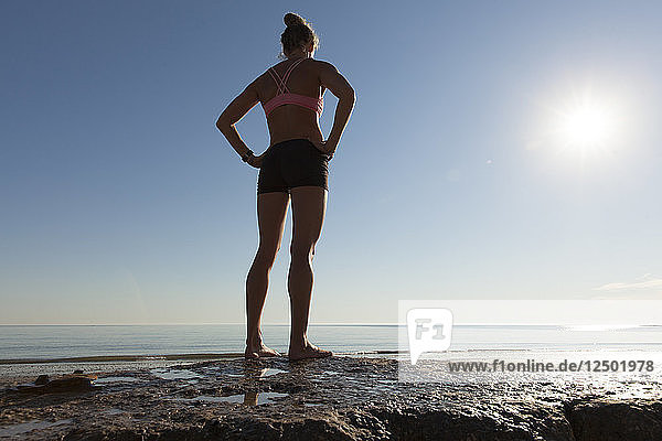 Rückansicht von Athlet Frau stehend am Strand