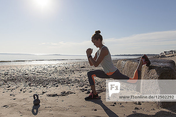 Frau macht Stretching am Strand