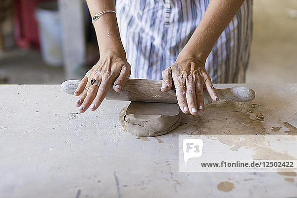 Frau Hand Schneiden Ton mit Faden in keramischen Werkstatt