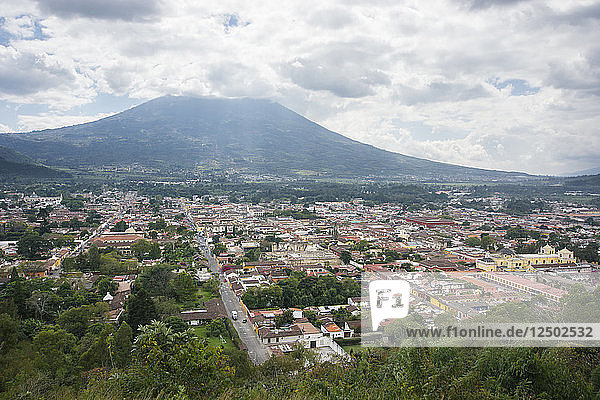 Blick auf die Stadt Antigua mit der Spitze des Volcan De Agua von Wolken im Hintergrund bedeckt