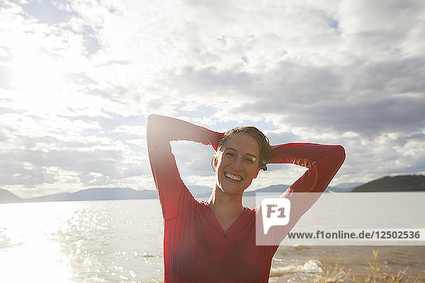 Porträt einer Frau  die ihr Haar vor dem Lake Pend Oreille auswringt