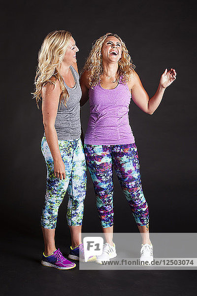 Zwei Freundinnen lachen zusammen in Trainingskleidung