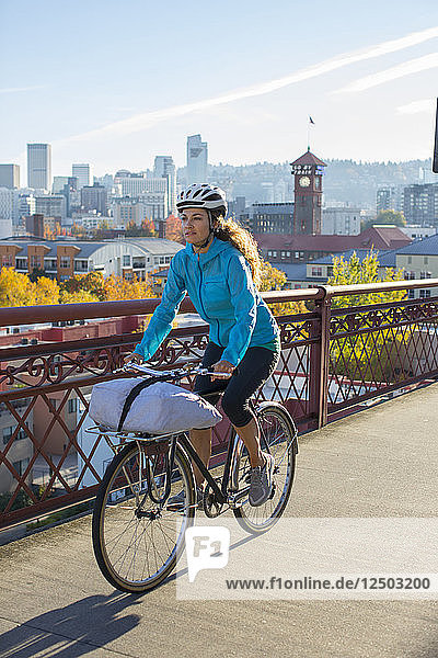 Eine erwachsene Frau fährt mit dem Fahrrad über die Broadway Bridge in Portland  Oregon. Willamette River.