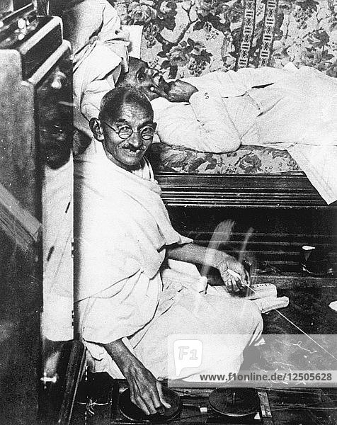 Mohondas Karamchand Gandhi (1869-1948)  bei der Arbeit an seinem Spinnrad. Künstler: Unbekannt