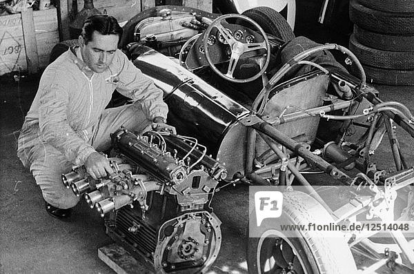 Jack Brabham inspecting the engine of a car. Artist: Unknown