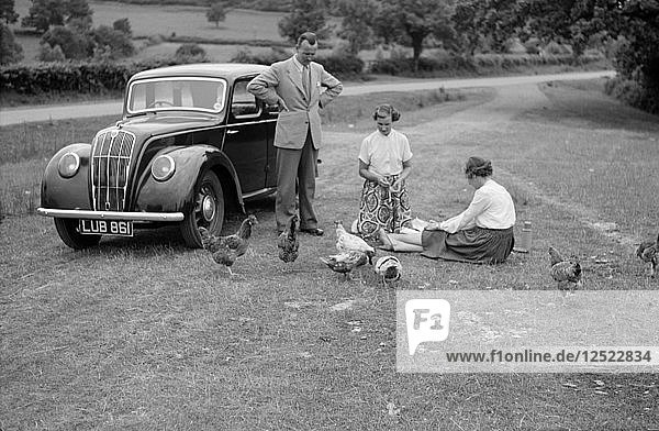 Eine Familiengruppe füttert Hühner neben ihrem Auto  ca. 1945-c1965. Künstler: SW Rawlings