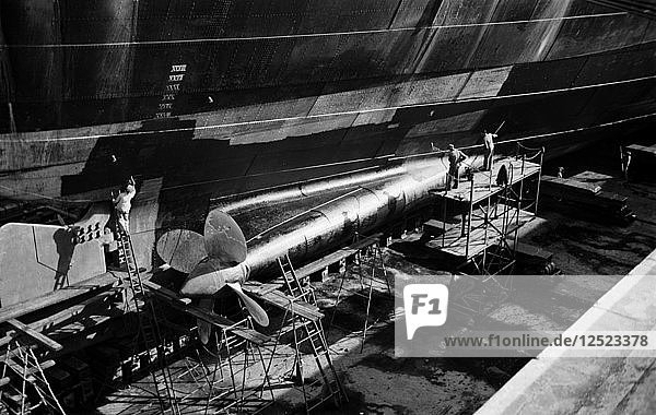 Men clean and paint the hull of a ship in the New Dry Dock  Tilbury Docks  Tilbury  c1945-c1965. Artist: SW Rawlings