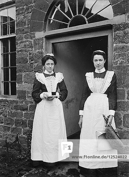 Zwei Hausmädchen stehen in der Tür eines Hauses  Byfield  Northamptonshire  ca. 1896-c1920. Künstler: A Newton