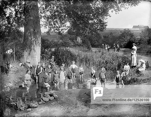 Children playing in a pool on a hot summers day Cowley Oxford Oxfordshire 1914. Artist: Henry Taunt