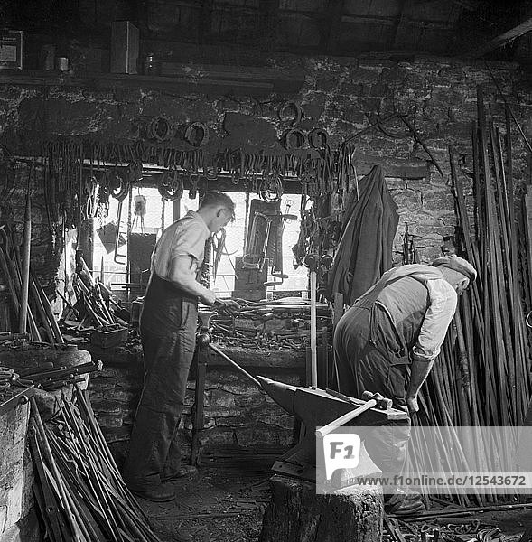 Männer bei der Arbeit in einer Schmiedewerkstatt  ca. 1946-c1959. Künstler: John Gay