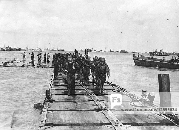 American troop debarkation on a pontoon built by the Seabees Normandy France 1944. Artist: Unknown