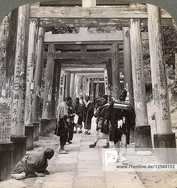 Coming and going under long rows of sacred torii  Shinto temple of Inari  Kyoto  Japan  1904. Artist: Underwood & Underwood
