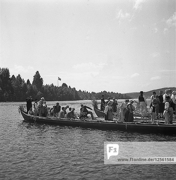 People arrive in long boats  called church boats  for the Midsummer celebrations  Sweden  1941. Artist: Torkel Lindeberg