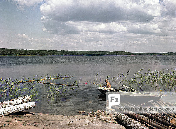 Ein Junge angelt in den Sommerferien von einem Ruderboot aus  Schweden  1950er Jahre. Künstler: Göran Algård