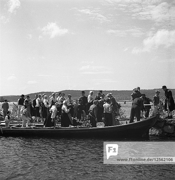 Die Menschen kommen in langen Booten  den so genannten Kirchenbooten  zu den Feierlichkeiten am Mittsommerabend und -tag an  1941. Künstler: Torkel Lindeberg