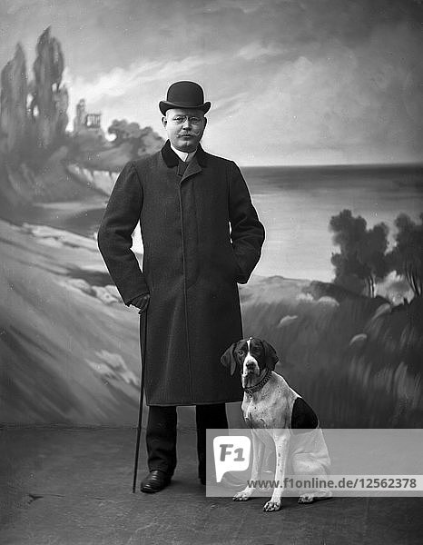 Elegant man wearing a black overcoat posing with his dog  Landskrona  Sweden  1910. Artist: Unknown