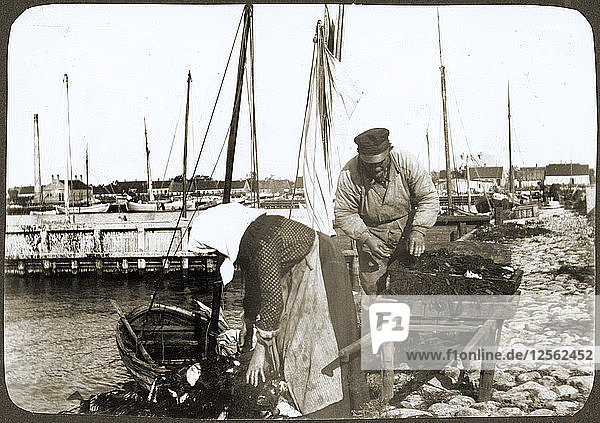 Ein Fischer und seine Frau mit Netzen und einer Schubkarre  Borstahusen  Landskrona  Schweden  1905. Künstler: Unbekannt