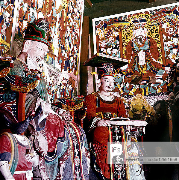 Thankas and statues of Taoist sages or monks inside the temple on Diamond Mountain.
