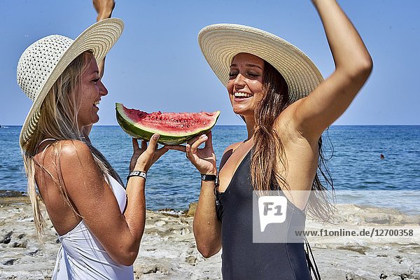 Two young women with water melon and sunhats. Chersonissos  Crete  Greece.
