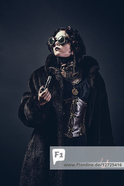 Steampunk woman standing holding a pipe