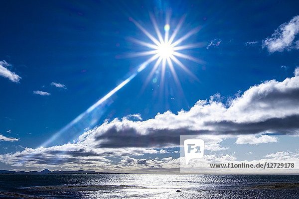 Sun shining above the ocean at the coastline of Reykjavic  Iceland.