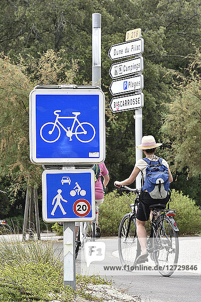 Frankreich  Pyla sur mer  Boulevard des Ozeans  Fahrradweg  Fahrradschild  Geschwindigkeitsbegrenzung  eine Frau auf ihrem Fahrrad  Rücken