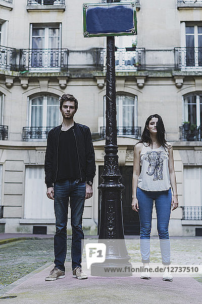 France  Paris  young couple standing at lamp post in front of urban building
