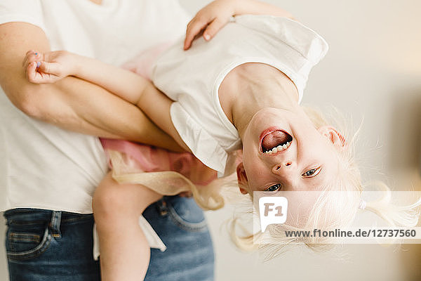 Portrait of happy little girl playing with her mother