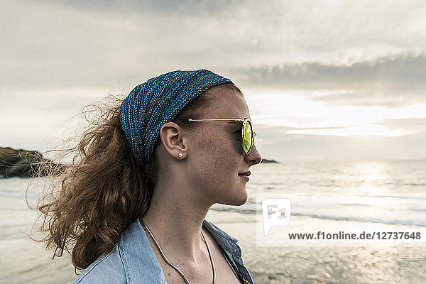 Young woman watching the sunset on the beach
