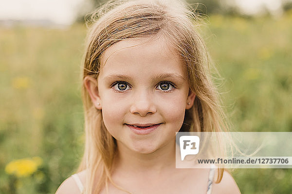 Portrait of blond little girl in nature