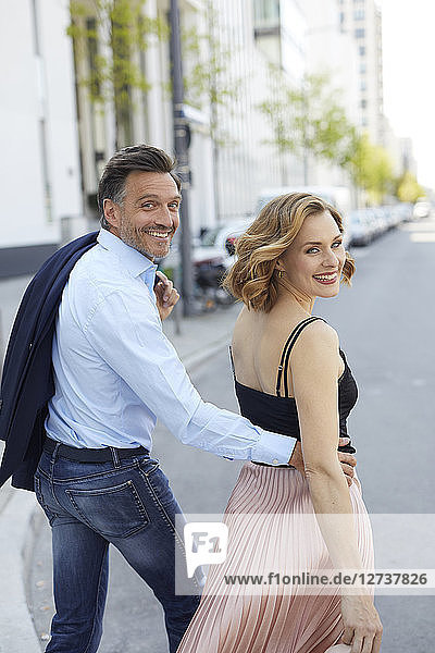 Portrait of happy couple crossing the street