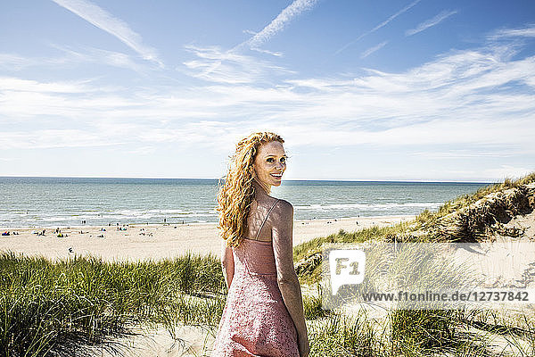 Netherlands  Zandvoort  portrait of smiling woman standing in dunes