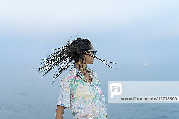 Woman tossing hair in front of the sea