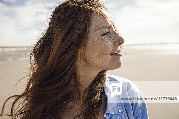 Portrait of a redheaded woman on the beach