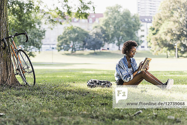 Young woman resting in park using tablet
