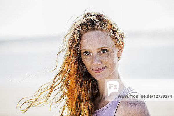 Portrait of smiling redheaded woman outdoors