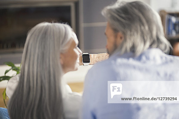Senior couple looking at smartwatch