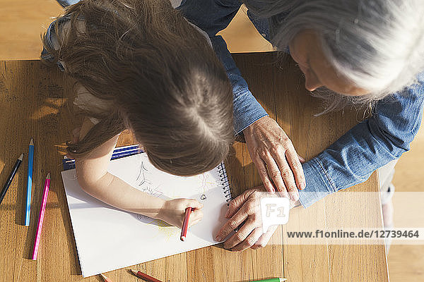 Grandmother and granddaughter making a drawing together