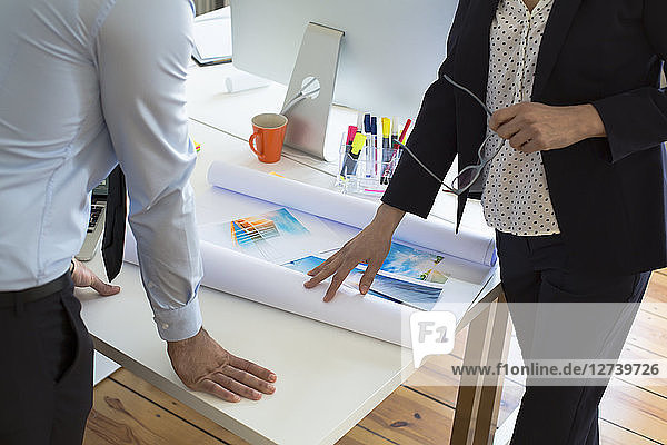 Businessman and businesswoman with printouts in office