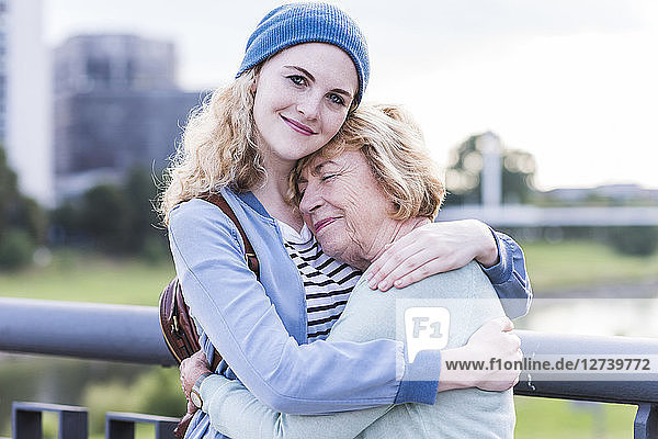 Portrait of young woman hugging her grandmother