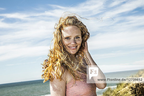 Netherlands  Zandvoort  portrait of smiling woman at the coast