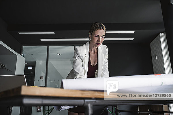 Businesswoman in office working on plan at desk