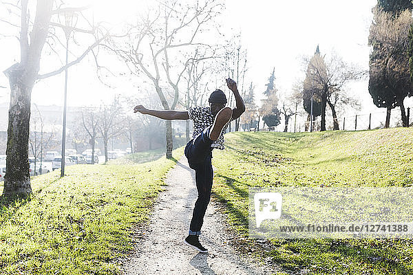 Young man exercising to kickbox in park